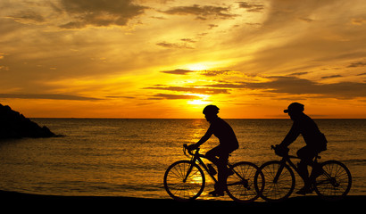 Fototapeta na wymiar Silhouette shot Cycling by the beach the sea The sun is falling 