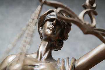 lady justice or iustitia - detail of blind or blindfolded bronze statue - law and legislation symbol