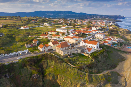 Aerial view of small town with red roofs on coastline Atlantic ocean. Top View of Azenhas Do Mar, Sintra, Portugal