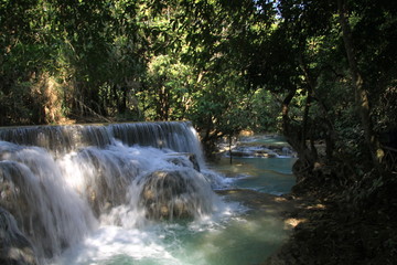 Scenic view on cascades and natural blue pool of idyllic Kuang Si waterfalls in jungle near Luang Prabang, Laos
