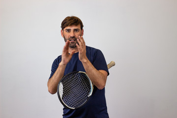 Portrait of handsome young man playing tennis holding a racket with brown hair giving a thumbs...