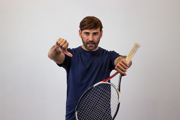 Portrait of handsome young man playing tennis holding a racket with brown hair showing the palms of...