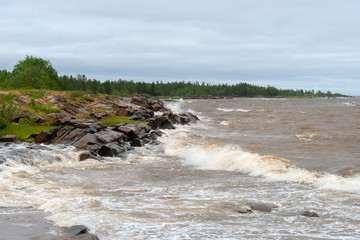 The strong waves of the White Sea crashing on the rocky shore