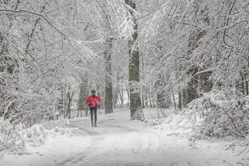 Fototapeta na wymiar Mann mit Roter Jacke im verschneiten Wald