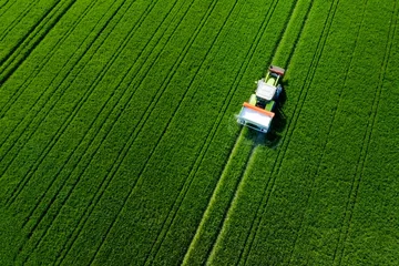 Abwaschbare Fototapete Grün Traktor von oben auf dem feld, Luftaufnahme