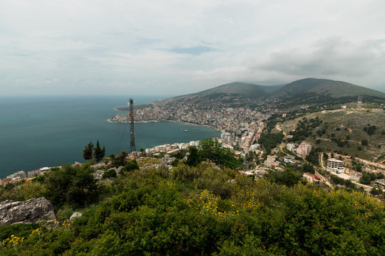 Panorama view onto the Albanian beach town Saranda from the lookout at Lekuresi Castle with cloudy sky (Saranda, Albania, Europe)