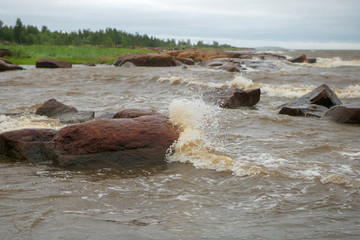 The strong waves of the White Sea crashing on the rocky shore
