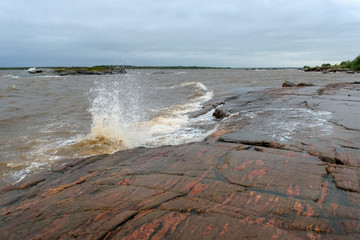 The strong waves of the White Sea crashing on the rocky shore
