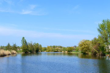Beautiful view of the river and blue sky. Summer landscape. Place to relax, picnic. Village.