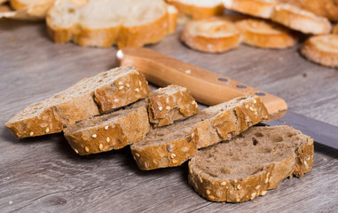 slices of wheaten bread and knife on wooden surface