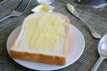 Sliced bread with butter on white dish for breakfast