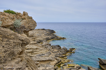 high cliffs and small cliffs by the sea, horizon as background