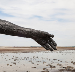 Woman's hand smeared with black healing mud.