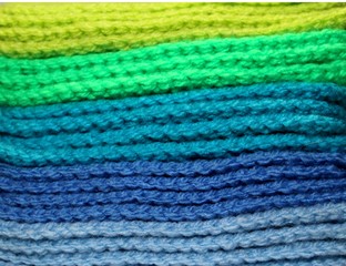 Fototapeta premium Colorful blue and green design background of knitted woolen elements in a pale