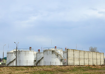 Fototapeta na wymiar Oil storage tanks at Fuel terminal. Industrial facility for storage of oil and petrochemical products ready for transport