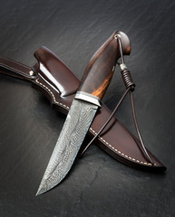 Hunting knife handmade on a black background. Leather Sheath Handmade