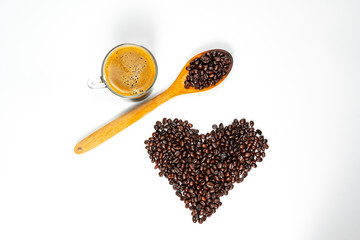 Top view of black coffee in clear glass cup  with dark roasted coffee bean form in heart shape and wood spoon on white background. I love coffee concept