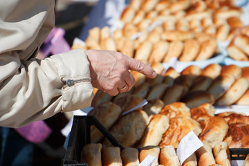 the hand of an elderly person, chooses food, pies