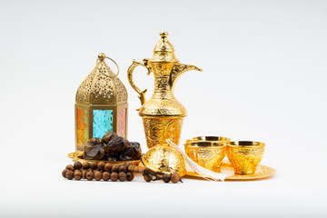 Fototapeta na wymiar Premium dates, lantern and arabic coffee mug on white background. Selective focus, copy space and Ramadan Kareem concept