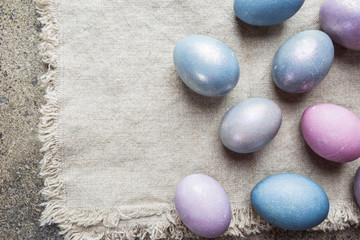 Colorful pastel easter eggs on stone background with space for text, top view.
