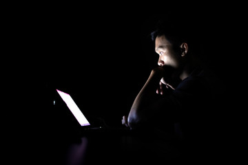 Lonely developer thinking solution with laptop at night in the dark room