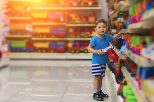 Small child choosing toys at the kid's store. Shopping for children.
