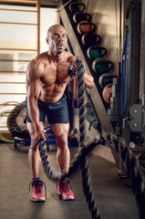 Bodybuilder workout with ropes