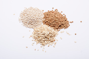 Three piles of grits, lentil and oatmeal.