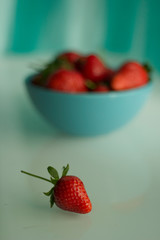 Fresh strawberries in a porcelain bowl on the table.