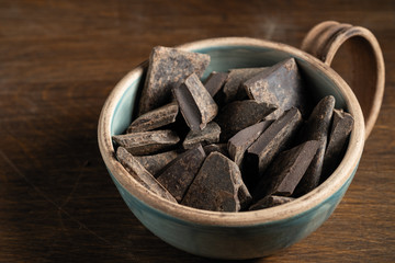 Natural chocolate without sugar from grated cocoa beans, in eco packaging on a dark background