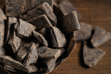 Natural chocolate without sugar from grated cocoa beans, in eco packaging on a dark background