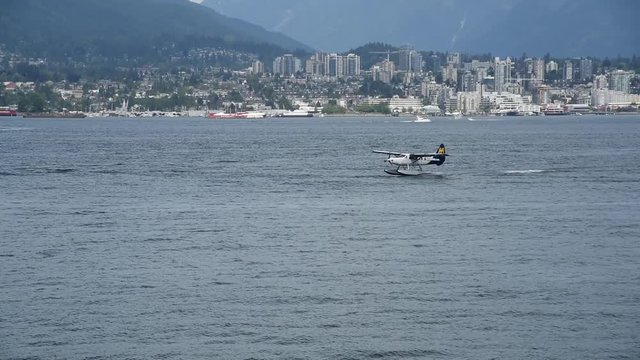 A seaplane is touching down to the sea.  Burrard Inlet Vancouver BC Canada      1     