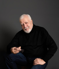 business, gray-haired man on a gray background seriously looking