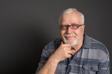 Obraz premium an adult, white-haired man with glasses smiles good-naturedly