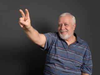 adult, white-haired man gestures number two