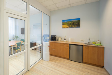 Office kitchen for employees with cooler and home appliances.