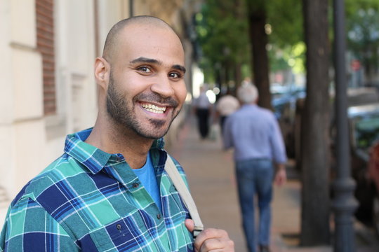 Handsome young ethnic man smiling with copy space