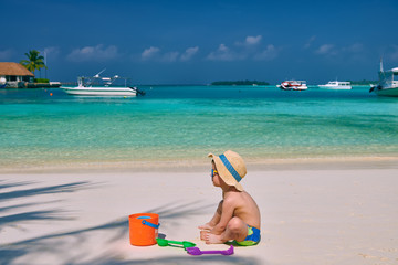 Three year old toddler playing on beach