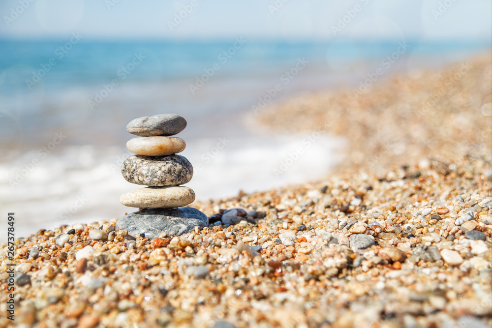 Wall mural balance of stones on the beach, sunny day