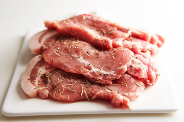 Fresh raw seasoned pork on cutting board 