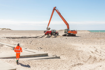 Fototapeta premium Excavator on the beach in Norre Vorupor, Denmark.