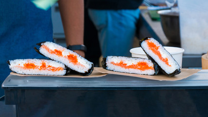 Japanese sushi rolls at russian street food market festival. Outdoor cooking, gastronomy, asian food and service concept