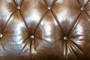 Surface of brown leather sofa. Leather with rivets.