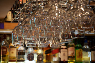 close-up of glasses fixed upside down in the muffled lighting of the bar