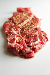 Fresh raw seasoned beef on white background 