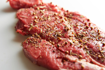 Fresh raw seasoned beef on white background 