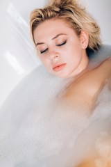 Blonde woman relaxing in bath