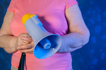 Beautiful senior woman is excited, euphoric, screaming with megaphone, sign of revolution and...