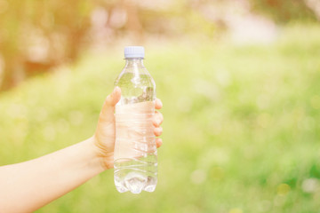 woman holding a plastic bottle with water in nature