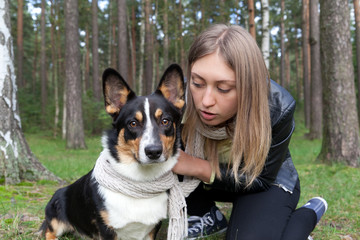 Pretty woman hugging her dog breed welsh corgi cardigan